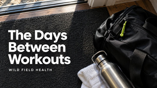 A gym bag, towel and steel bottle by a home doorway, with the headline The Days Between Workouts.
